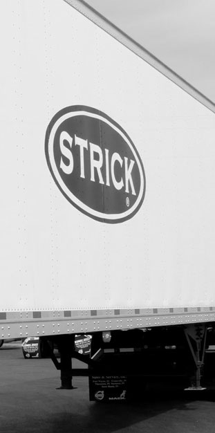 Strick semi-trailer manufacturer logo on the side of a sheet and post trailer Strick semi-trailer manufacturer logo on the side of a sheet and post trailer
